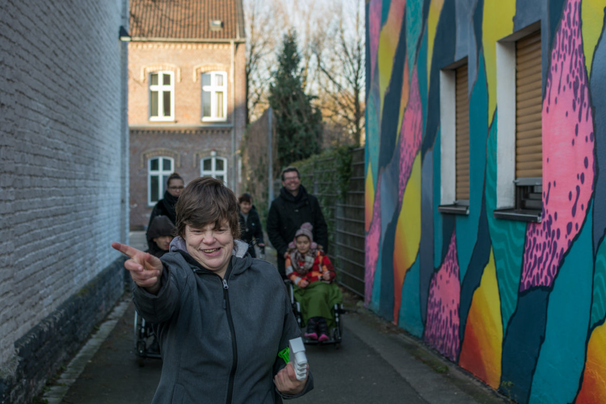 Die Teamleiter vom Projekt machen einen Spaziergang mit den Klienten durch eine Gasse